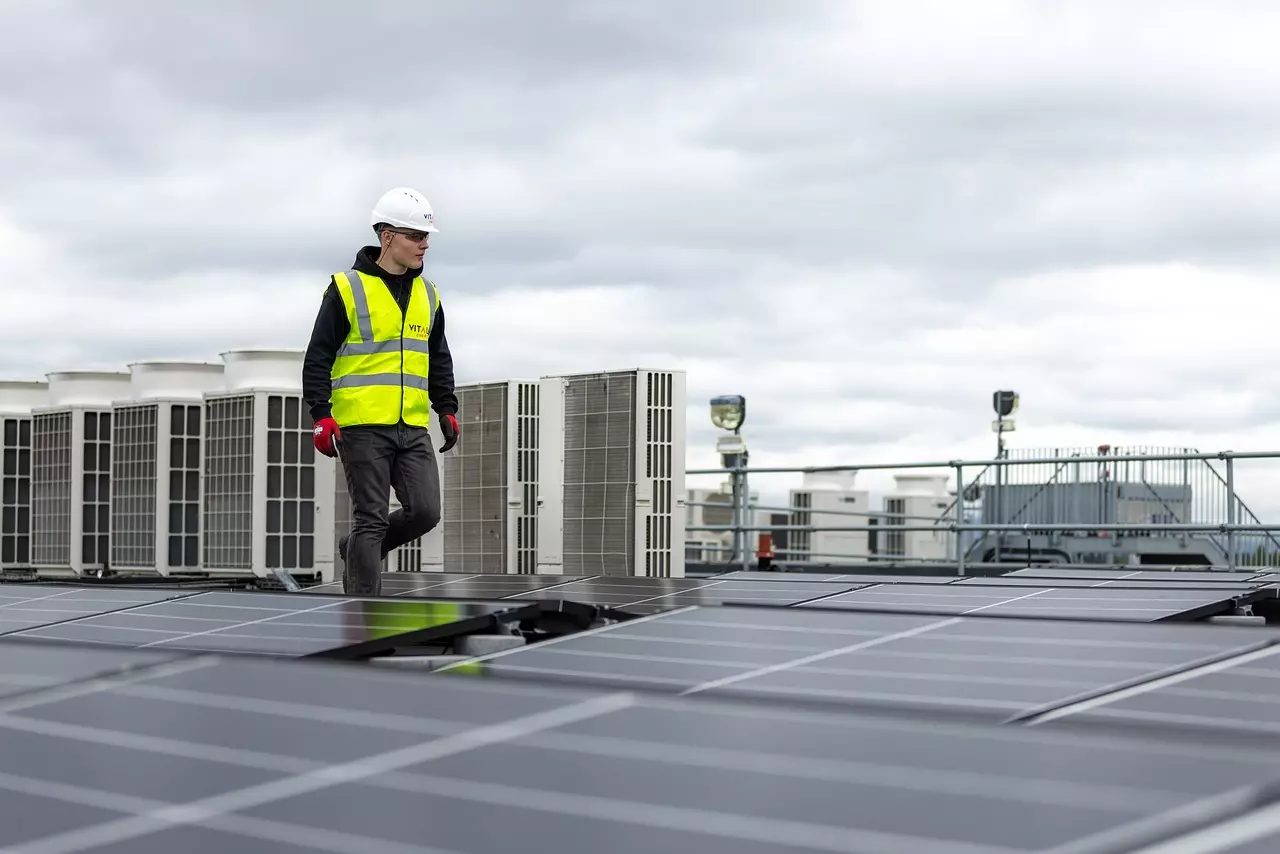 Mann auf einem Dacht mit Solarpanel